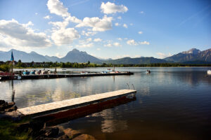 Hopfensee mit Bootsanleger und Bergen im Hintergrund 2015