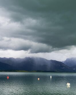 Segelboot auf dem Forggensee vor stürmischem Himmel