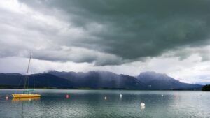 Segelboot auf dem Forggensee vor stürmischem Himmel