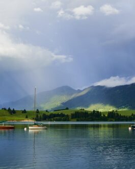 Segelboote auf dem Forggensee bei Sonnenstrahlen und Wolken