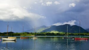 Segelboote auf dem Forggensee bei Sonnenstrahlen und Wolken