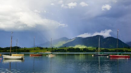 Segelboote auf dem Forggensee bei Sonnenstrahlen und Wolken