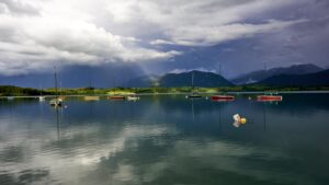 Segelboote auf dem Forggensee bei wechselndem Wetter