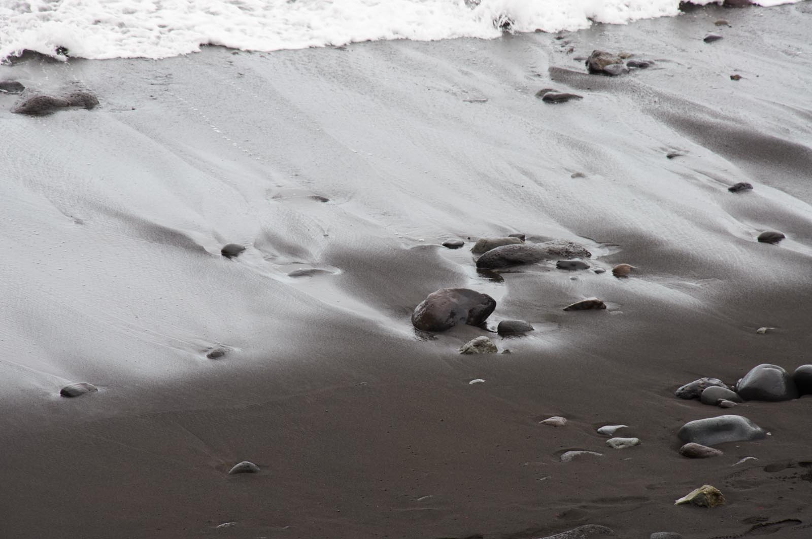 Schwarzer Strand im sanften Wellengang