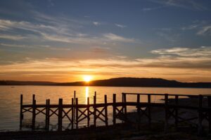 Sonnenuntergang über dem Bodensee mit Holzsteg