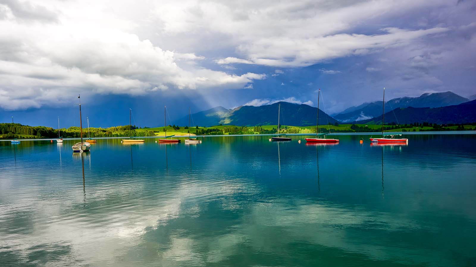 Segelboote auf dem Forggensee bei wechselndem Wetter